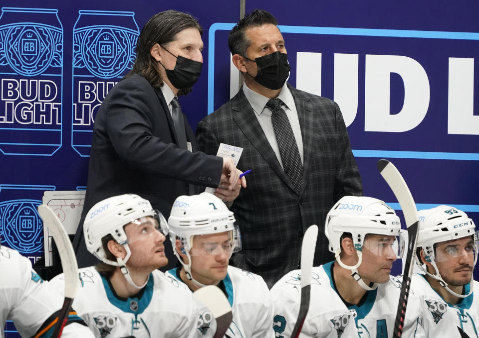 San Jose Sharks coach Bob Boughner, right, confers with assistant coach Mike Ricci during the second period of the team's NHL hockey game against the Colorado Avalanche on Tuesday, Jan. 26, 2021, in Denver. (AP Photo/David Zalubowski)
