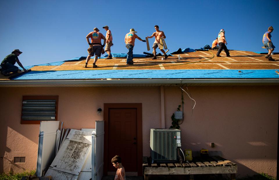 Volunteers with Eight Days of Hope replace a roof on a home in Harlem Heights on Monday, May 22, 2023. Eight Days of Hope, a non-profit is back in Southwest Florida with  hundreds of volunteers helping families affected by Hurricane Ian.  