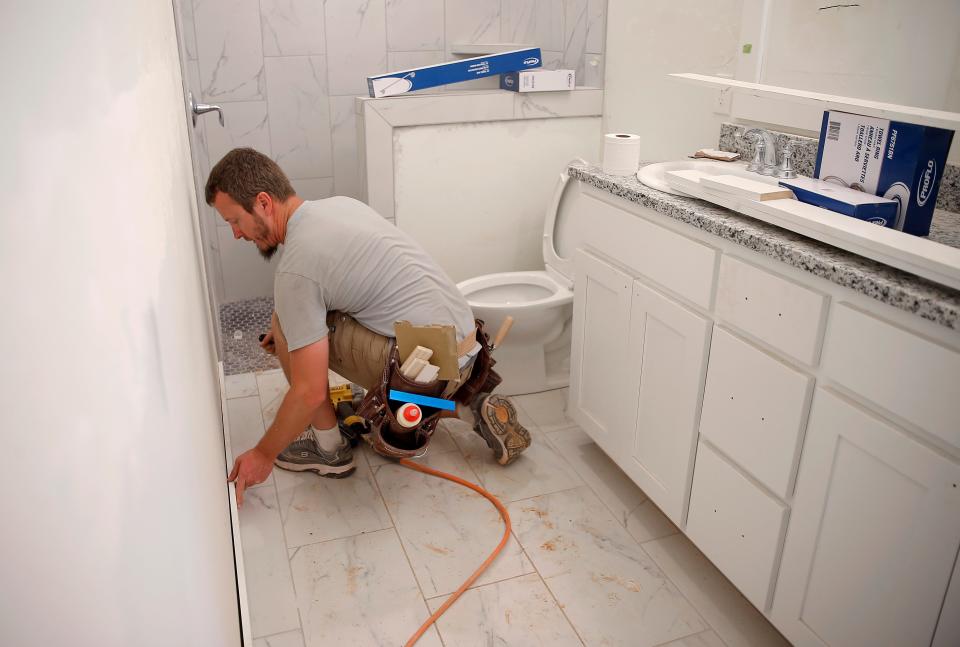 Brent Wonsch installs baseboards in a house by Two Structures Homes on E Seventh Street in Arcadia.