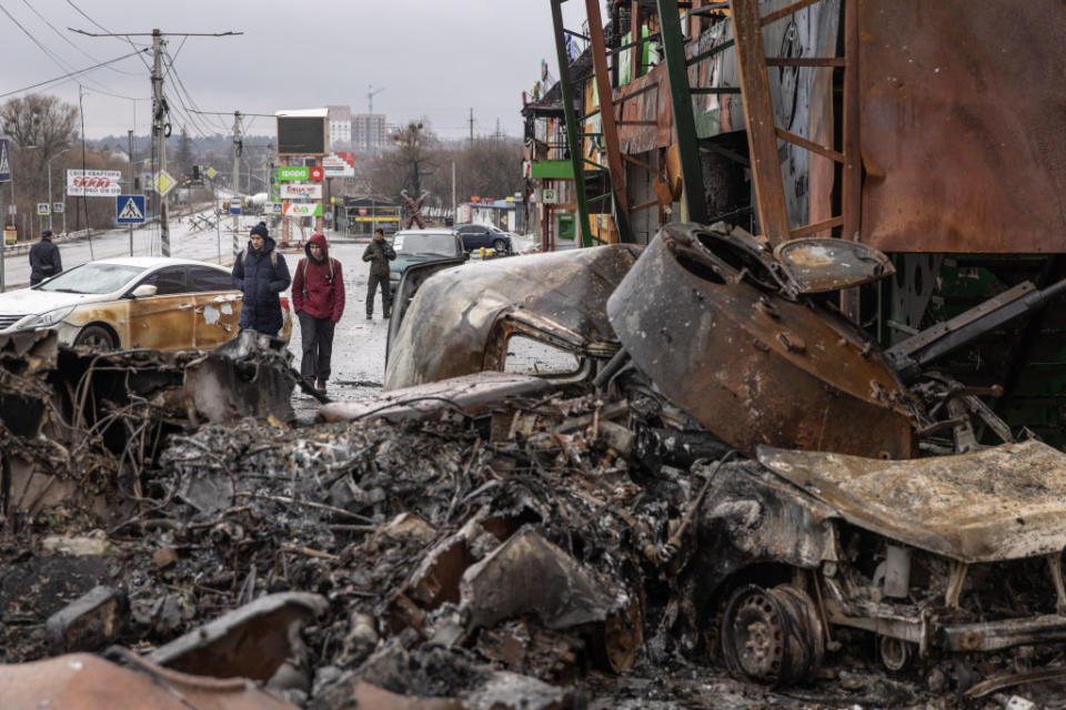 People walk past a destroyed Russian military vehicle at a frontline position on March 03, 2022 in Irpin, Ukraine.