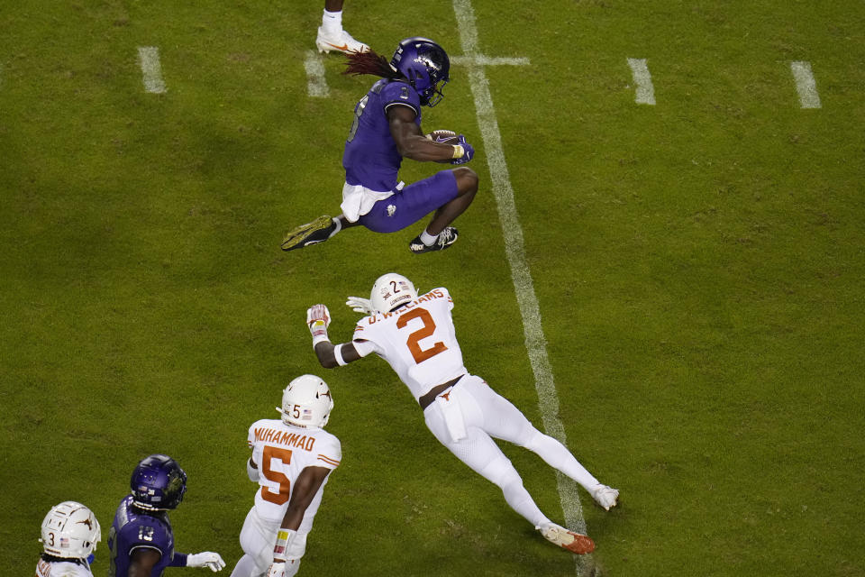 TCU wide receiver Savion Williams, top, leaps over the tackle attempt of Texas defensive back Derek Williams Jr. (2) during the second half of an NCAA college football game, Saturday, Nov. 11, 2023, in Fort Worth, Texas. Texas won 29-26. (AP Photo/Julio Cortez)