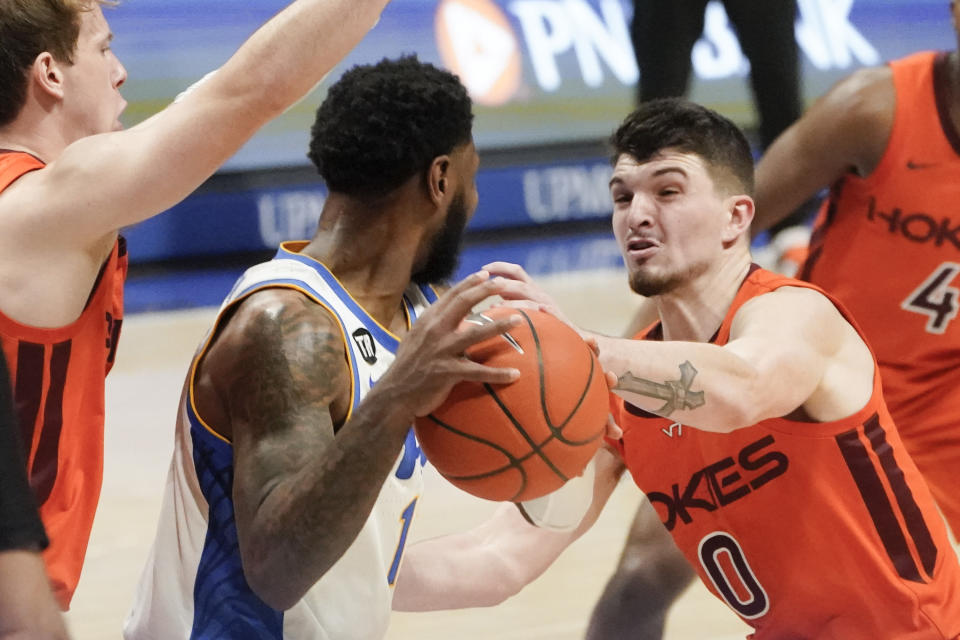 Virginia Tech's Hunter Cattoor (0) defends as Pittsburgh's Jamarius Burton looks to pass the ball during the second half of an NCAA college basketball game, Saturday, Feb. 5, 2022, in Pittsburgh. (AP Photo/Keith Srakocic)