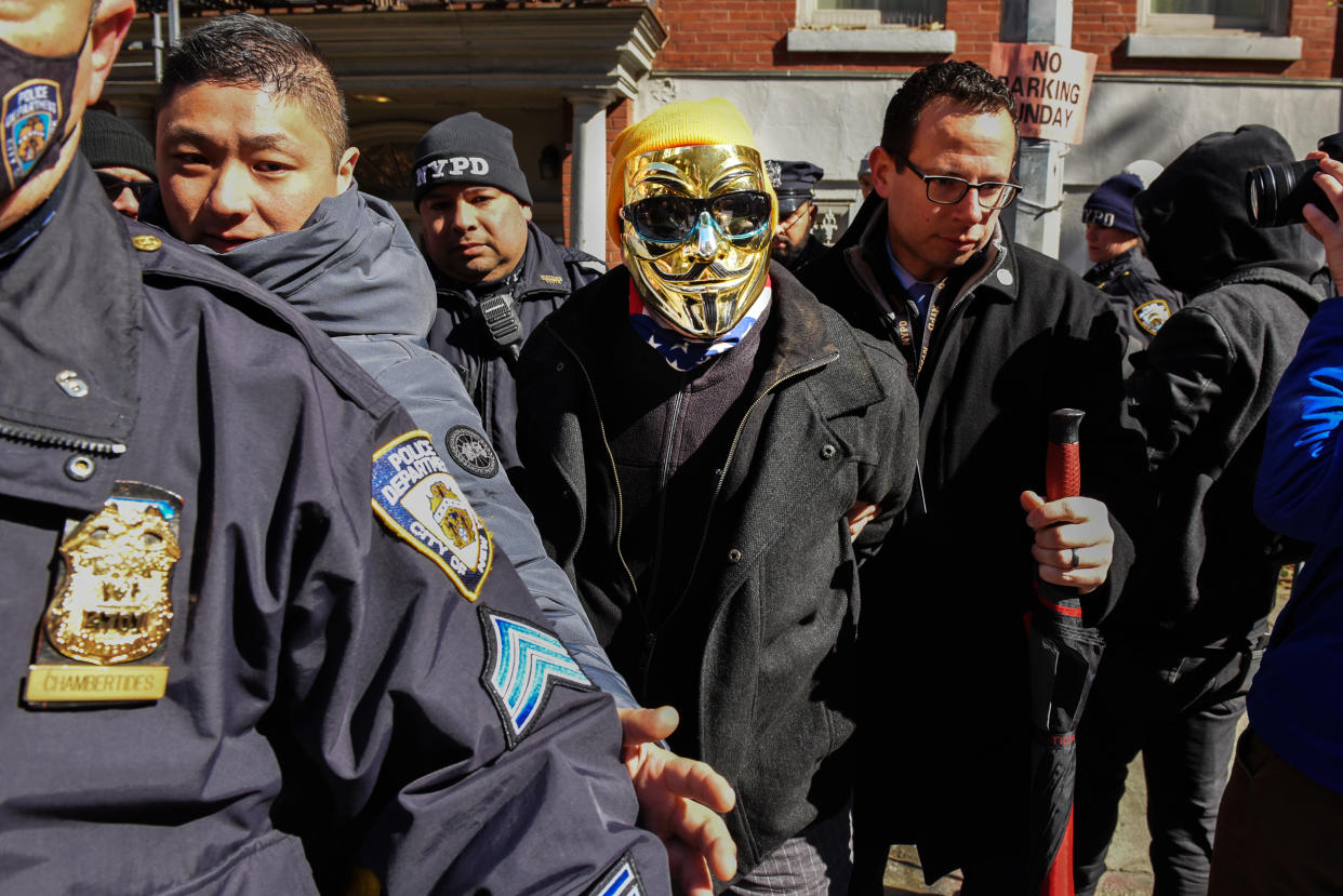  A man in a gold Anonymous mask is detained at a protest against Drag Queen story hour outside of The Center, a support space for LGBTQ+ people on March 19, 2023 in New York City.  (Stephanie Keith / Getty Images)