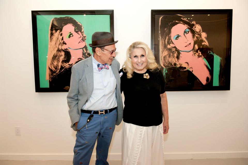 Artist Bruce Helander and Jane Holzer pose near Andy Warhol's 1975 portraits of Holzer, during the reception.