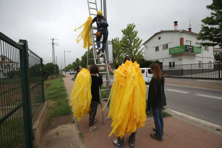 Members of Granoller's Committee for the Defence of the Republic (CDR) hang yellow ribbons to demand the release of jailed Catalonian politicians in Granollers, Spain May 12, 2018. REUTERS/Albert Gea