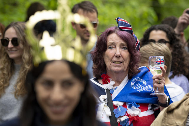 A woman holding a glass sings during the Big Lunch celebrations in London's Regent's Park, Sunday, May 7, 2023. Sunday, May 7, 2023. The Big Lunch is part of the weekend of celebrations for the Coronation of King Charles III. (AP Photo/Andreea Alexandru)