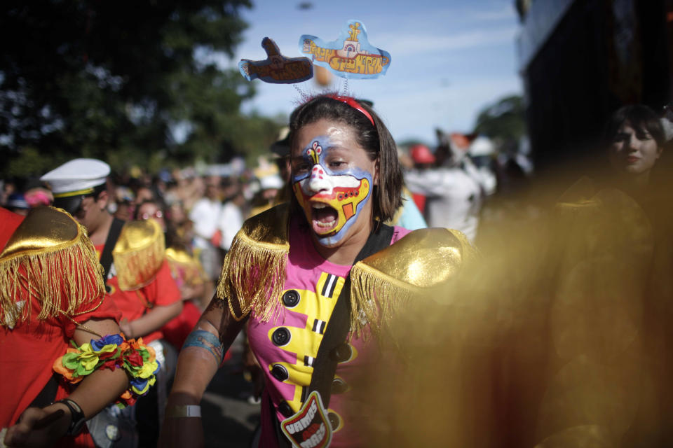 A reveler, her face painted with the iconic Beatles' Yellow Submarine, participates in the Beatles-themed street party, "Sargento Pimenta," Portuguese for "Sergeant Pepper," at the Aterro do Flamengo urban park in Rio de Janeiro, Brazil, Monday Feb. 20, 2012. The group that organizes the party gives the Beatles repertoire a Brazilian tweak, adapting "All My Loving" to the peppy beat of a traditional Carnival "marchinha," or march, and infusing "Hard Day's Night" with a Rio funk sound. (AP Photo/Dado Galdieri)