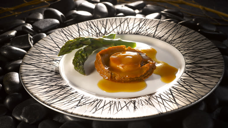 Plated abalone on dark background