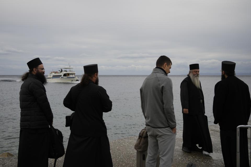 Orthodox monks and priests wait for the boat in the Mount Athos, northern Greece, on Friday, Oct. 14, 2022. The monastic community was first granted self-governance through a decree by Byzantine Emperor Basil II, in 883 AD. Throughout its history, women have been forbidden from entering, a ban that still stands. This rule is called "avaton" and the researchers believe that it concerns every form of disturbance that could affect Mt. Athos. (AP Photo/Thanassis Stavrakis)