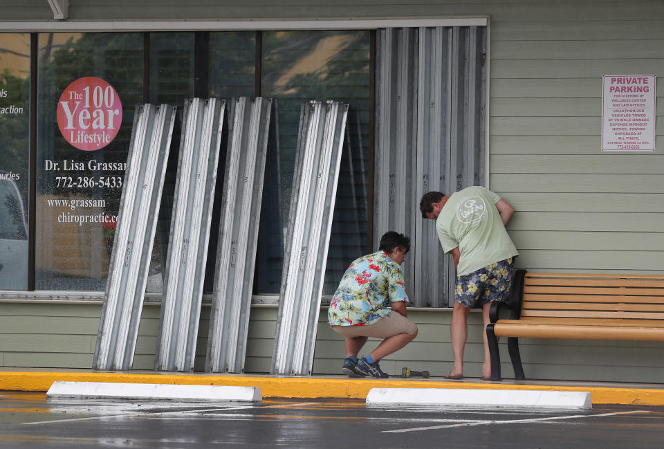 STUART, FLORIDA - AUGUST 01: Donald Bowen (L) and Doug Smith put shutters over the windows of their business as Tropical Storm Isaias approaches on August 01, 2020 in Stuart, Florida. The storm is expected to brush past the east coast of Florida within the next 24 hours. (Photo by Joe Raedle/Getty Images)