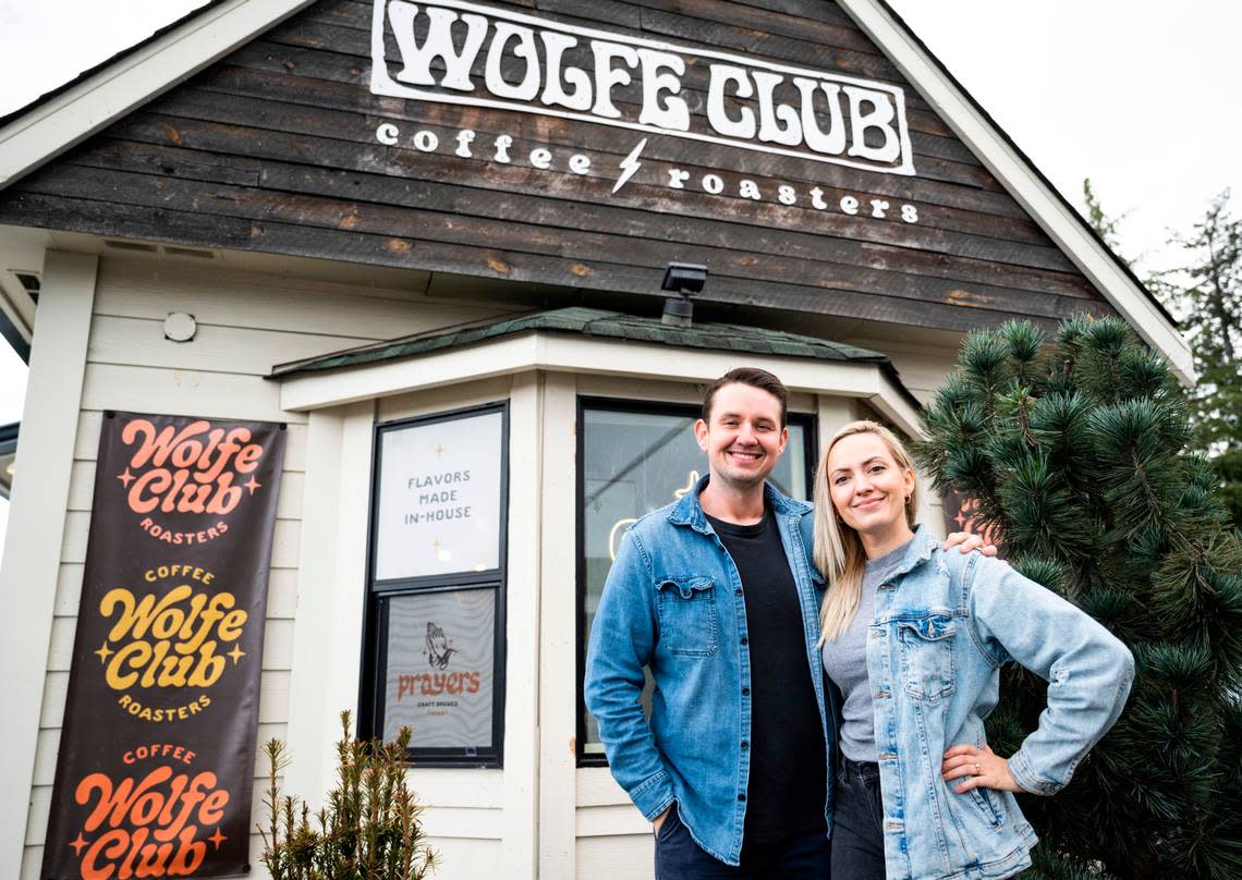 Wolfe Club owner Mark Larkin and his sister, Kristen Basargin, pose for a portrait in front of the drive-through coffee stand in Parkland, Wash. on Oct. 24, 2022. Larkin is “just full of ideas,” said Basargin, who designs all of the shop’s custom stickers, shirts and other swag.