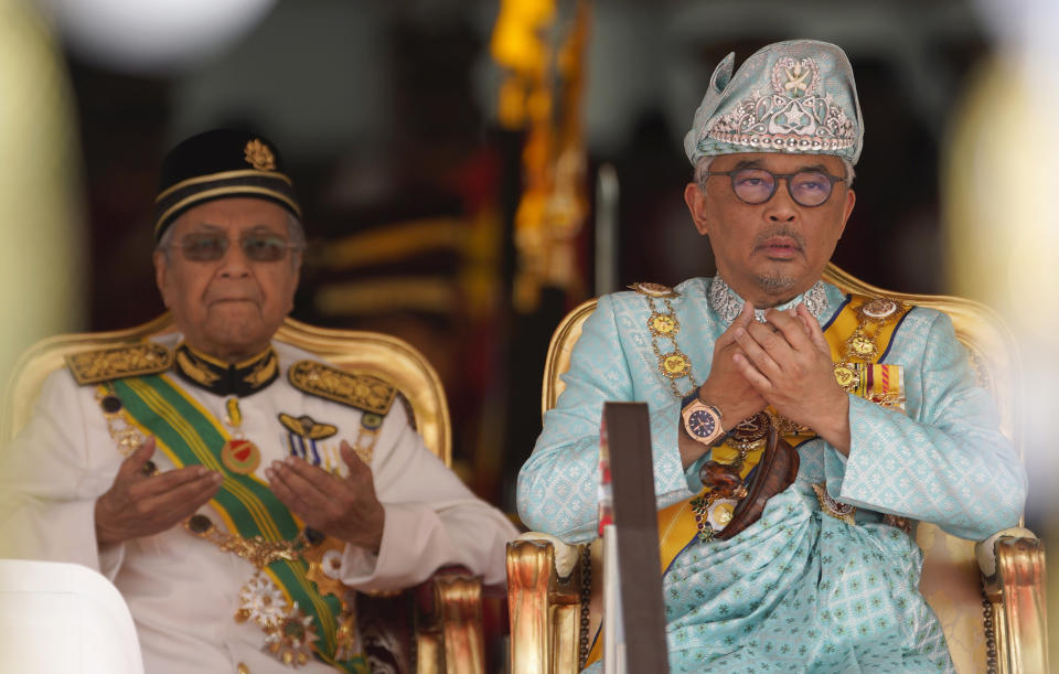 In this Thursday, Jan. 31, 2019, file photo, Malaysia's King Sultan Abdullah Sultan Ahmad Shah, right, prays next to Prime Minister Mahathir Mohamad during his welcome ceremony at Parliament House in Kuala Lumpur, Malaysia. Sultan Abdullah, ruler of central Pahang state, was named Malaysia's new king, replacing Sultan Muhammad V who abdicated unexpectedly after just two years on the throne. (AP Photo/Yam G-Jun, FIle)