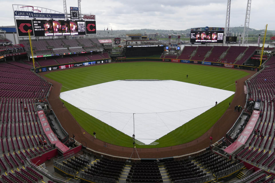 The tarp covers the field as it rains before the start of a baseball game between the Baltimore Orioles and Cincinnati Reds on Friday, May 3, 2024, in Cincinnati. (AP Photo/Carolyn Kaster)