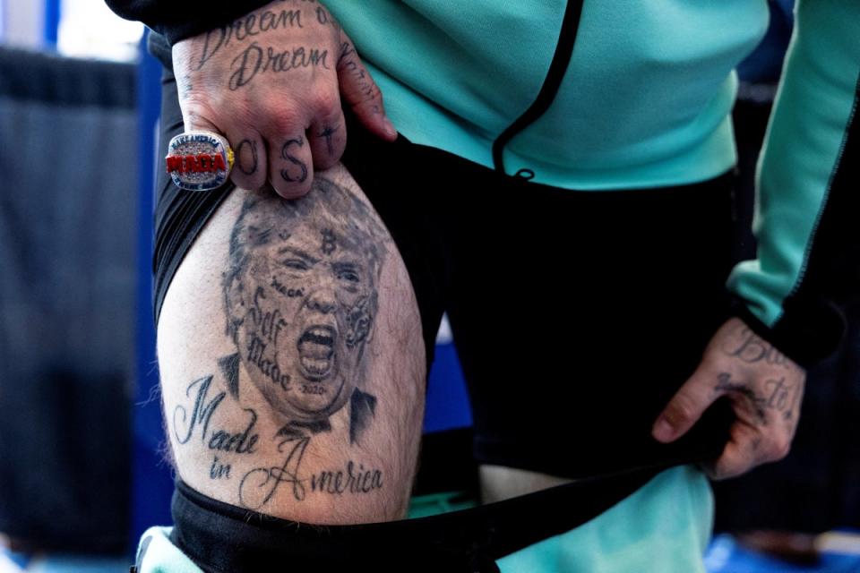 Rapper Forgiato Blow shows a person his Trump-themed tattoo at the Conservative Political Action Conference (CPAC) annual meeting in National Harbor, Maryland, U.S., February 22, 2024 (REUTERS)
