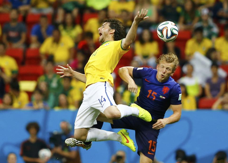 Brazil's Maxwell (L) and Dirk Kuyt of the Netherlands fight for the ball during their 2014 World Cup third-place playoff at the Brasilia national stadium in Brasilia July 12, 2014. REUTERS/Dominic Ebenbichler (BRAZIL - Tags: SOCCER SPORT WORLD CUP)