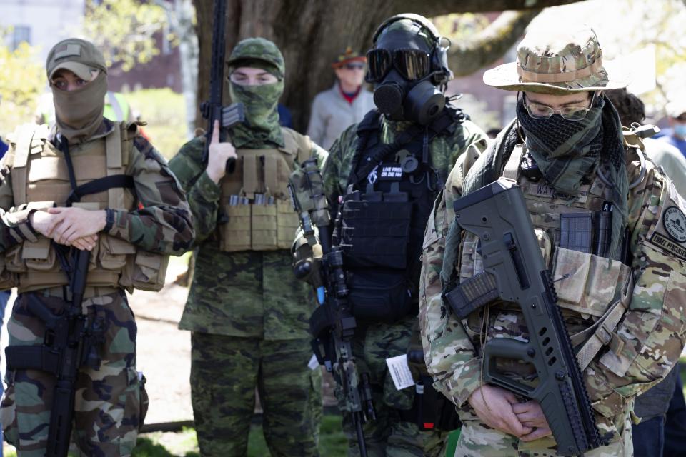 In this May 2, 2020, file photo, people, including those with the boogaloo movement, pray as they demonstrate against business closures due to concern about COVID-19, at the State House in Concord, N.H.  Experts warn that the anti-government boogaloo movement has attracted a dangerous element of far-right extremists. (Michael Dwyer/AP File photo)