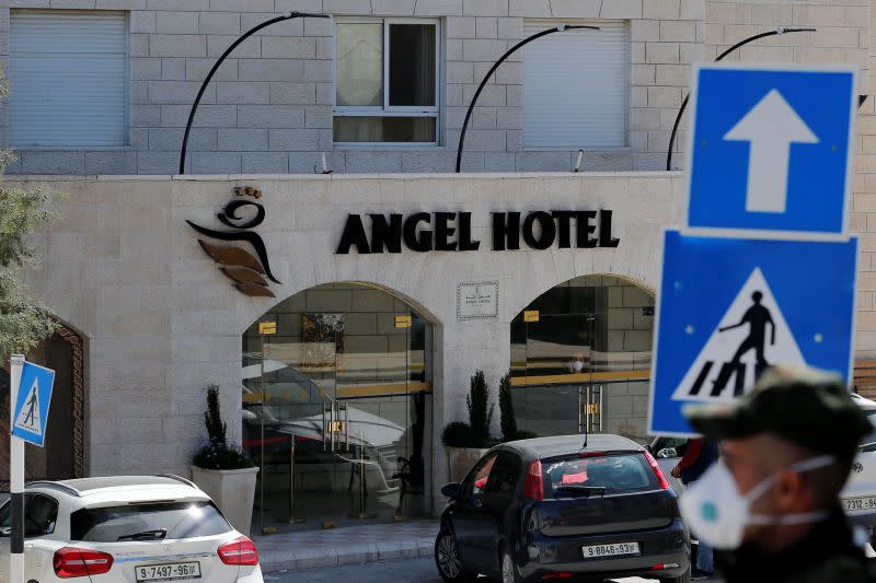 A member of Palestinian security forces wearing a mask as a preventive measure against the coronavirus stands guard outside Angel hotel in Beit Jala town in the Israeli-occupied West Bank