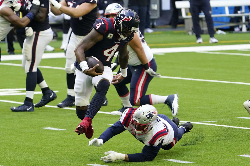 Houston Texans quarterback Deshaun Watson (4) leaps from the grasp of New England Patriots defensive end Tashawn Bower (96) during the first half of an NFL football game, Sunday, Nov. 22, 2020, in Houston. (AP Photo/David J. Phillip)