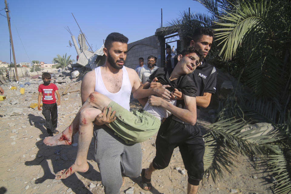 Palestinians evacuate a wounded youth after an Israeli airstrike in Rafah, Gaza Strip, Friday, Oct. 13, 2023. (AP Photo/Hatem Ali)