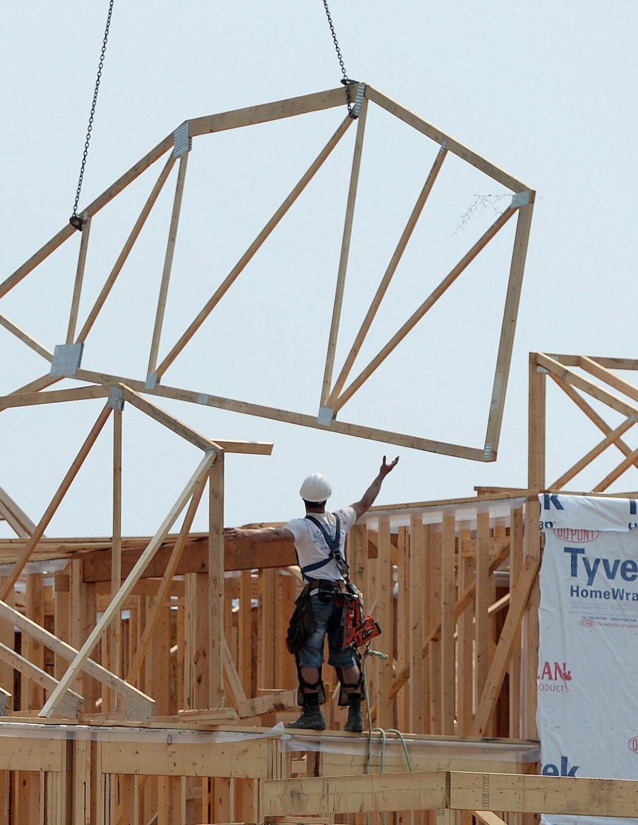 Construction workers build new homes in a development in Ottawa on Monday, July 6, 2015. Canada Mortgage and Housing Corp. says the annual pace of housing starts picked up in March. (Sean Kilpatrick/The Canadian Press - image credit)