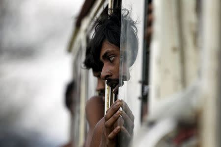 Migrants, who were found at sea on a boat, sit in a bus as they are moved to Taung Pyo sub-township after landing near Kanyin Chaung jetty outside Maungdaw township, northern Rakhine state, Myanmar June 3, 2015. REUTERS/Soe Zeya Tun