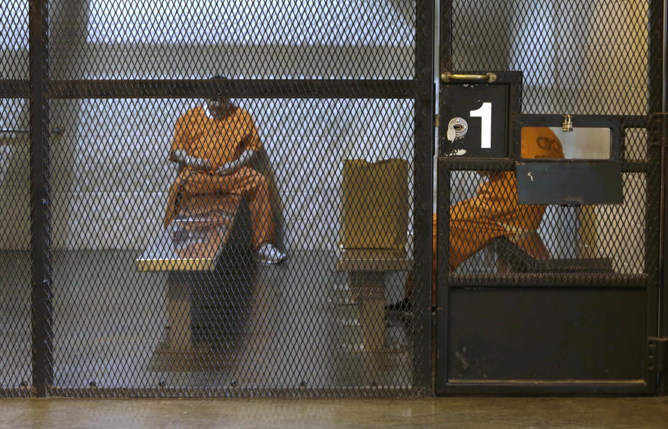 In this photo taken Thursday, Feb. 20, 2014, new arrivals from county jails wait in a holding unit before being assigned to cells at the Deuel Vocational Institution in Tracy, Calif. California counties are thwarting the state's efforts to comply with a federal court order to reduce it's inmate population by sending state prisons far more convicts than anticipated including a record number of second-strikers. The state is trying to comply with a landmark restructuring of its criminal justice system through a nearly 3-year-old law pushed by Gov. Jerry Brown that keeps lower-level felons in county jails while reserving scarce state prison cells for serious, violent and sexual offenders.(AP Photo/Rich Pedroncelli)