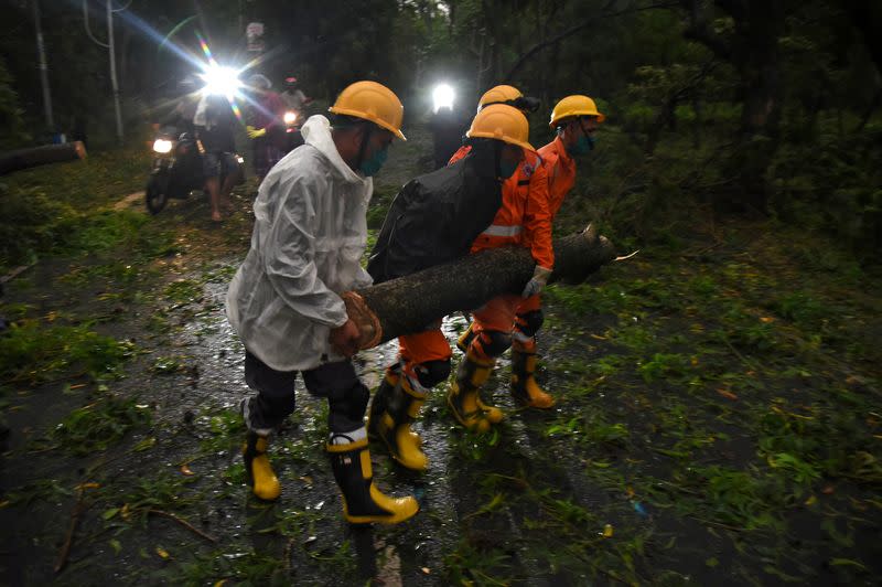 Members of National Disaster Rescue Force remove a branch of an uprooted tree after Cyclone Amphan made its landfall, in Digha