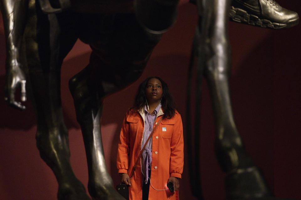 A woman looks at a bronze sculpture by Kehinde Wiley titled "An Archeology of Silence," at the de Young Museum in San Francisco, Friday, March 24, 2023. The sculpture is part of the "Kehinde Wiley: An Archaeology of Silence," exhibition. (AP Photo/Godofredo A. Vásquez)