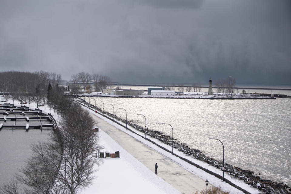 Dark clouds hover over water shining under a shaft of sunlight at Erie Basin Marina at about 11:30 a.m., in Buffalo, N.Y., Friday, Nov. 18, 2022. (Libby March/The Buffalo News via AP)