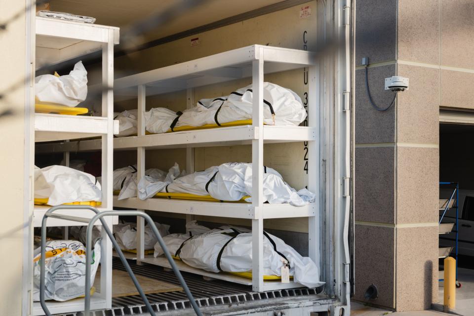 Bodies wrapped in plastic line the walls inside a refrigerated trailer used as a mobile morgue by the El Paso County Medical Examiner's office. Source: Getty