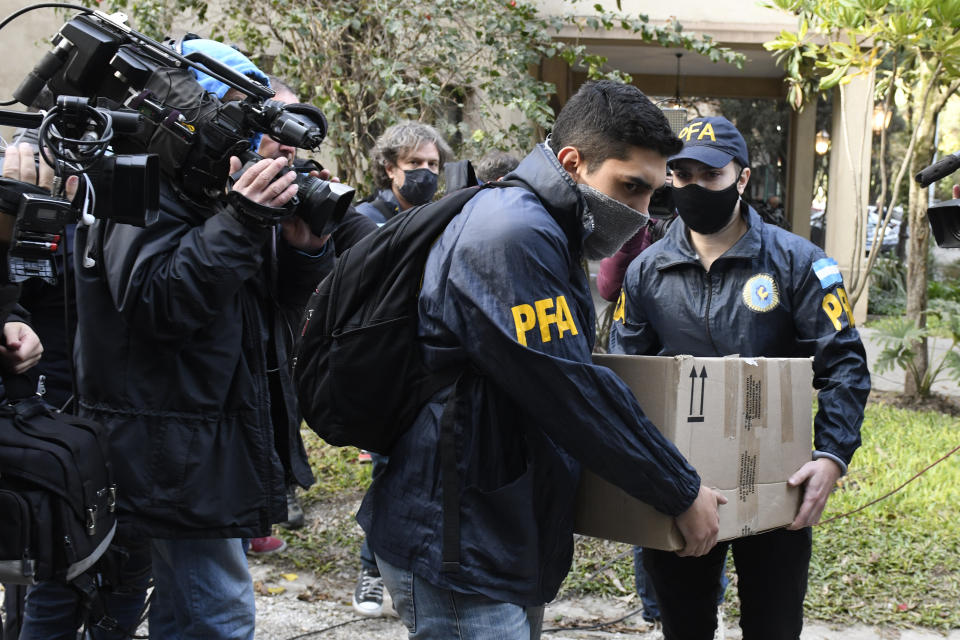 Police officers confiscate a box of documents during a judicial raid at the Plaza Central Hotel where the crew of a Venezuelan-owned Boeing 747 cargo plane are staying, in Buenos Aires, Argentina, Tuesday, June 14, 2022. Argentine officials are trying to determine what to do with the cargo plane loaded with automotive parts and an unusually large crew of 17, including at least five Iranians. The plane operated by Venezuela’s state-owned Emtrasur cargo line has been stuck since June 6 at Buenos Aires’ main international airport, unable to depart because of U.S. sanctions against Iran. and suspicions about its crew. (AP Photo/Gustavo Garello)