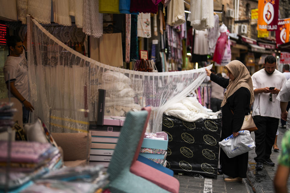 A seller helps a customer at Eminonu commercial area in Istanbul, Turkey, Tuesday, June 20, 2023. The Turkish central bank faces a key test Thursday June 22, 2023, on turning to more conventional economic policies to counter sky-high inflation after newly reelected President Recep Tayyip Erdogan gave mixed signals about an approach that many blame for worsening a cost-of-living crisis. (AP Photo/Francisco Seco)