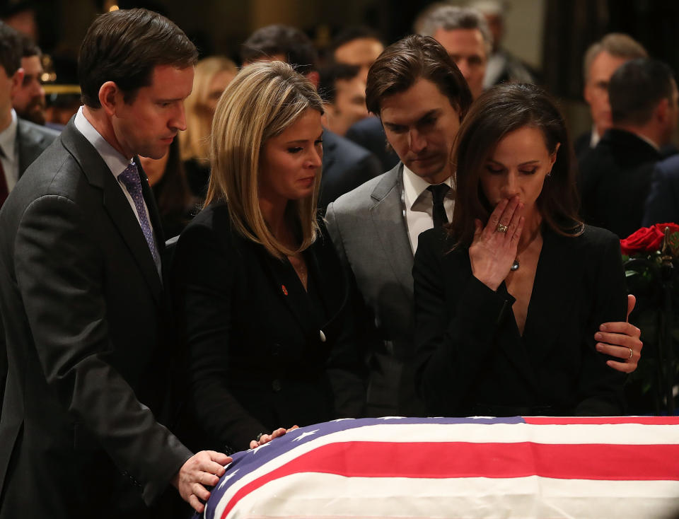 Jenna Bush Hager and her sister Barbara Bush stand with their husbands Henry Chase Hager, left, and Craig Coyne, second right, as they pay respect in front of the casket.