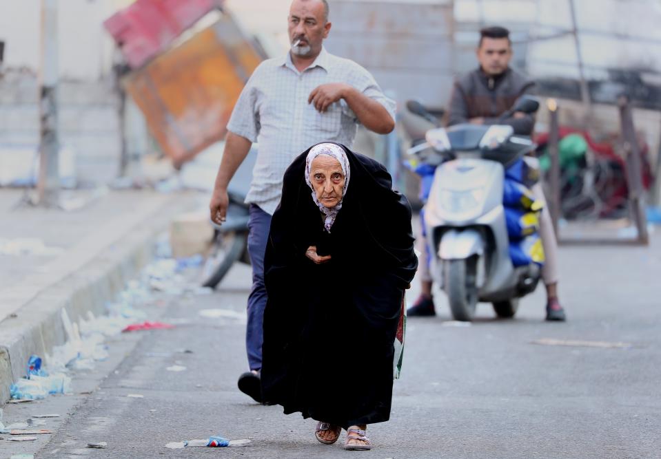 An elderly woman walks towards Tahrir Square during anti-government protests in Baghdad, Iraq, Thursday, Oct. 31, 2019. (AP Photo/Hadi Mizban)