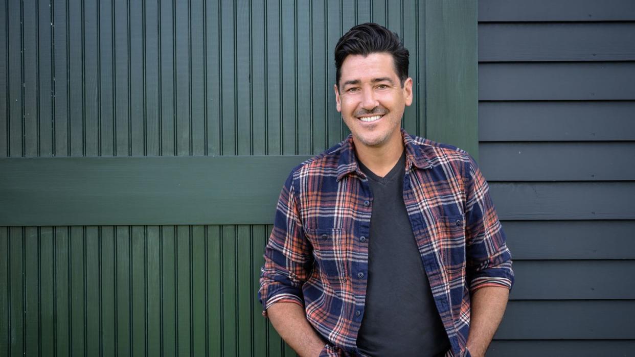 jonathan knight in front of the restored barn at his new england farmhouse, as seen on farmhouse fixer