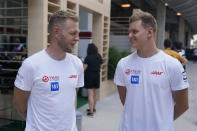 Haas driver Kevin Magnussen, left, of Denmark, speaks with Haas driver Mick Schumacher, of Germany, during the team's walkthrough of the race circuit ahead of the Formula One Miami Grand Prix auto race at Miami International Autodrome, Thursday, May 5, 2022, in Miami Gardens, Fla. (AP Photo/Darron Cummings)