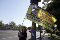 A supporter of the California recall of Gov. Gavin Newsom holds a sign outside of a debate by Republican gubernatorial candidates at the Richard Nixon Presidential Library Wednesday, Aug. 4, 2021, in Yorba Linda, Calif. Newsom faces a Sept. 14 recall election that could remove him from office. (AP Photo/Marcio Jose Sanchez)