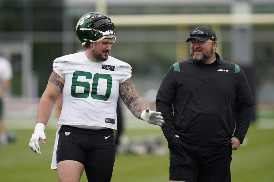 New York Jets’ general manager Joe Douglas, right, talks with Connor McGovern during a practice at the NFL football team’s training facility in Florham Park, N.J., Tuesday, May 24, 2022. (AP Photo/Seth Wenig)