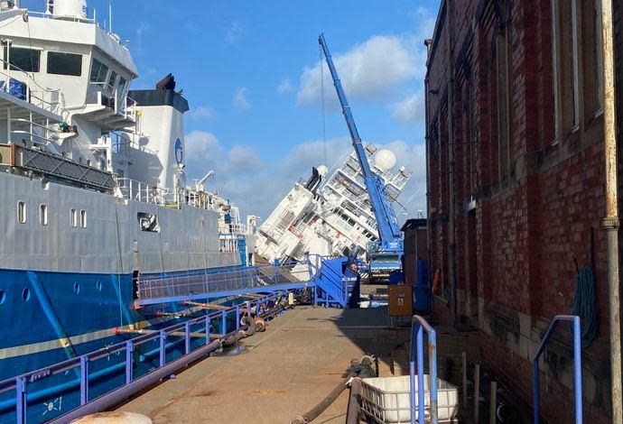The Petrel research vessel leans against the side of a dry dock in Leith, Scotland, March 22, 2023, after apparently being knocked over by high winds. / Credit: Twitter / @Tomafc83