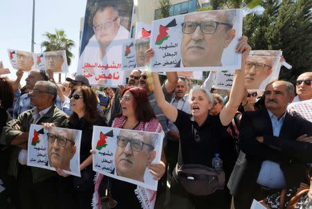 Relatives and activists hold pictures of the Jordanian writer Nahed Hattar, who was shot dead, and shout slogans during a sit-in in front of the prime minister's building in Amman, Jordan, September 26, 2016. REUTERS/Muhammad Hamed