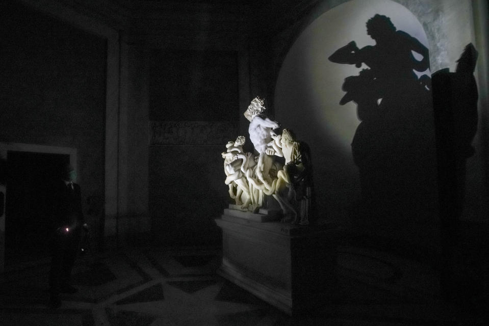 Gianni Crea, the Vatican Museums chief "Clavigero" key-keeper, illuminates the Laocoon statue, a masterpiece of the sculptors of Rhodes dated around 40-30 B.C., on his way to open the museum's rooms and sections, at the Vatican, Monday, Feb. 1, 2021. Crea is the “clavigero” of the Vatican Museums, the chief key-keeper whose job begins each morning at 5 a.m., opening the doors and turning on the lights through 7 kilometers of one of the world's greatest collections of art and antiquities. The Associated Press followed Crea on his rounds the first day the museum reopened to the public, joining him in the underground “bunker” where the 2,797 keys to the Vatican treasures are kept in wall safes overnight. (AP Photo/Andrew Medichini)