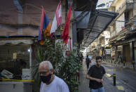 The Lebanese flag, center, the Armenian national flag, left, and the Armenian Revolutionary Federation flag fly in the main Armenian district of the northern Beirut suburb of Bourj Hammoud, Lebanon, Tuesday, Oct. 6, 2020. In Bourj Hammoud anger and anxiety are clear among the population over the fighting between Armenian and Azerbaijani forces in the separatist region of Nagorno-Karabakh that broke out on Sept. 27 and has left dozens killed since then. Hundreds of fighters from around the Middle East are heading to Nagorno-Karabakh in Azerbaijan to join rival countries fighting over the region. (AP Photo/Hassan Ammar)