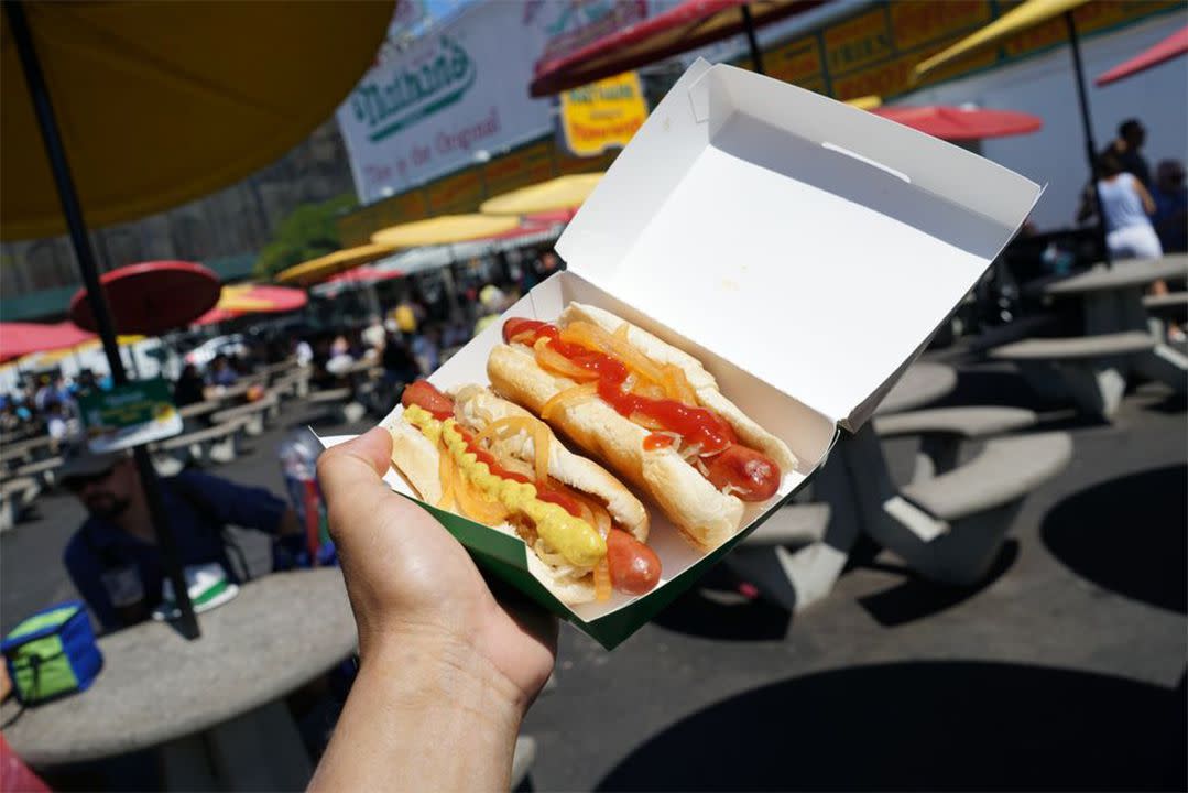 Nathan's Famous Hot Dogs in a box with stand in background