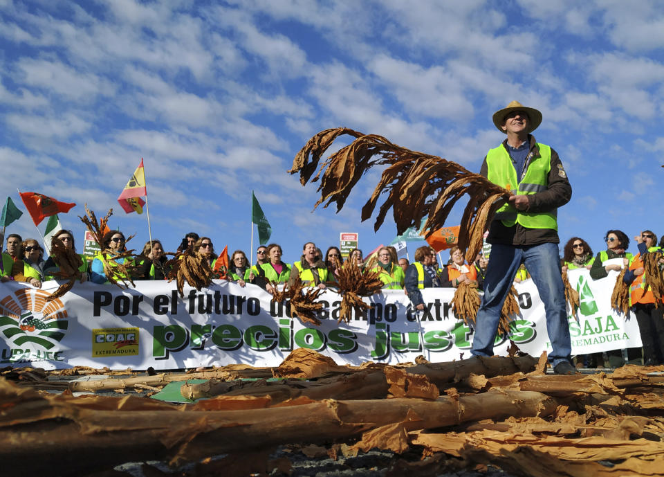 Farmers protest blocking the motorway near Navalmoral de la Mata in Caceres province, Spain, on Tuesday, February 18, 2020. Farmers in fluorescent yellow vests have begun blocking highways in southwestern Spain with tractors and other vehicles in the latest mass protest over what they say are plummeting incomes for agricultural workers. (AP Photo/Alicia Leon)