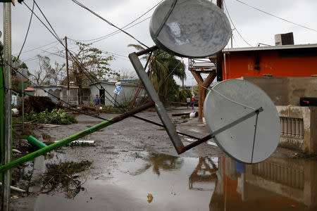 People walk next to damaged houses after the area was hit by Hurricane Maria in Salinas, Puerto Rico September 21, 2017. REUTERS/Carlos Garcia Rawlins