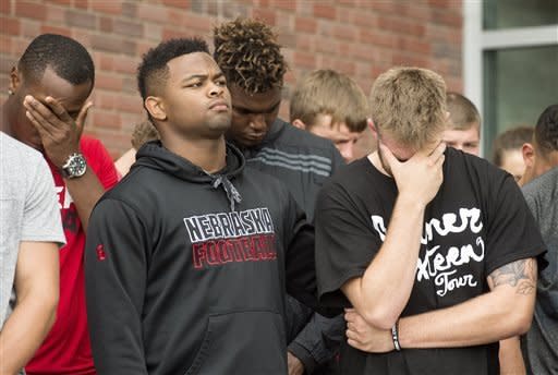 Nebraska football players attend a vigil for Nebraska punter Sam Foltz, Sunday, July 24, 2016, in Lincoln, Neb. Foltz and former Michigan State punter Mike Sadler died in a car crash in Wisconsin after working at a kicking clinic, a sheriff's department official said Sunday. LSU kicker Colby Delahoussaye was injured in the crash. (Francis Gardler/The Journal-Star via AP)