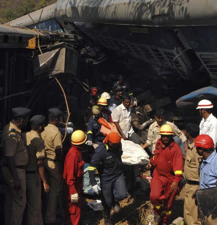 Rescuers remove the body of a passenger from the debris of a passenger train after it derailed near Nidi village in Maharashtra May 4, 2014. REUTERS/Stringer