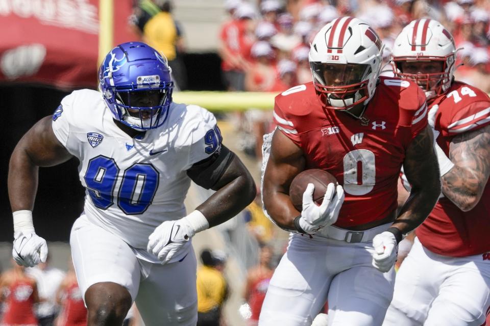 Wisconsin's Braelon Allen (0) runs -past Buffalo's George Wolo (90) during the first half of an NCAA college football game Saturday, Sept. 2, 2023, in Madison, Wis. (AP Photo/Morry Gash)