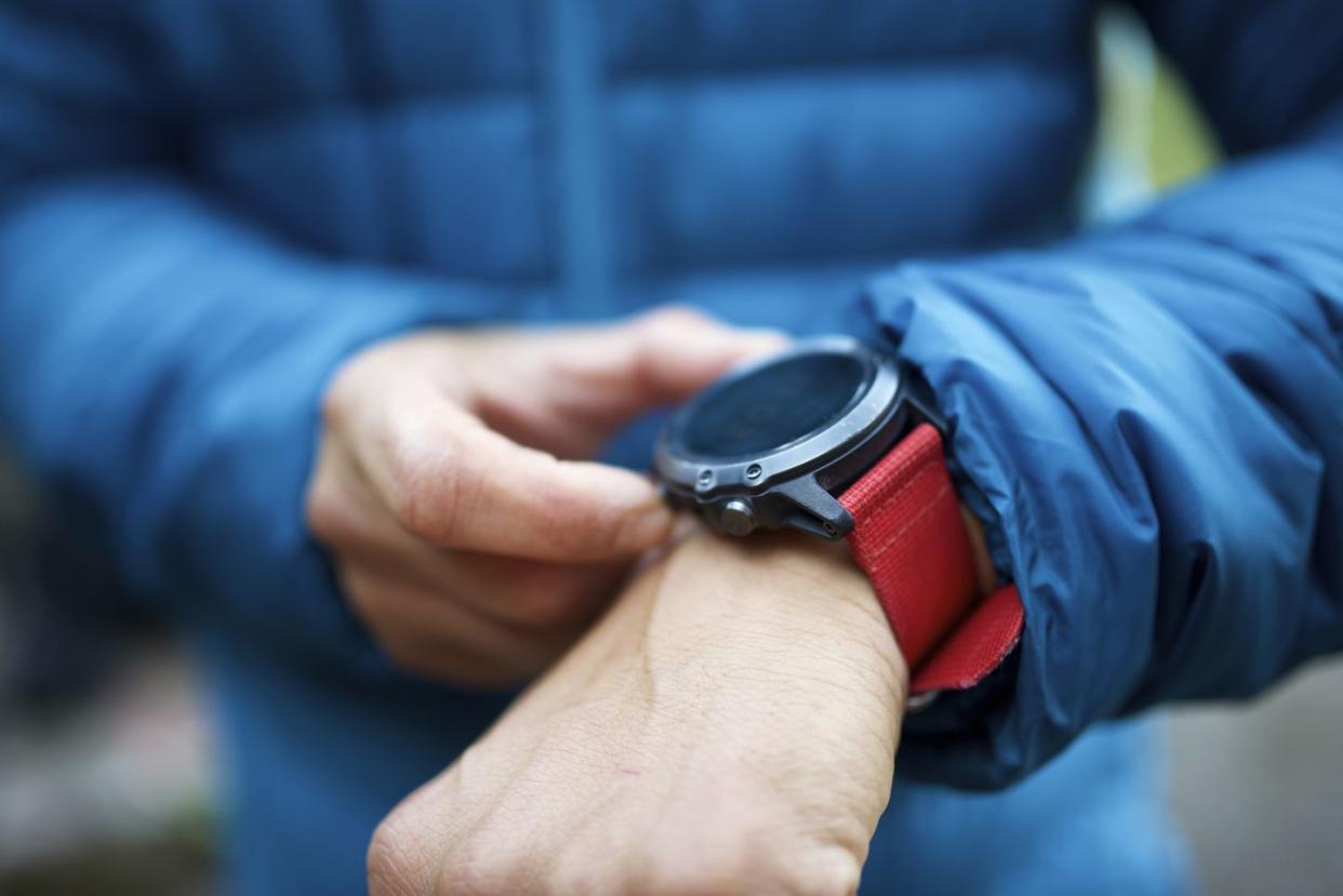 midsection of man wearing warm clothing wearing smart watch while standing outdoors