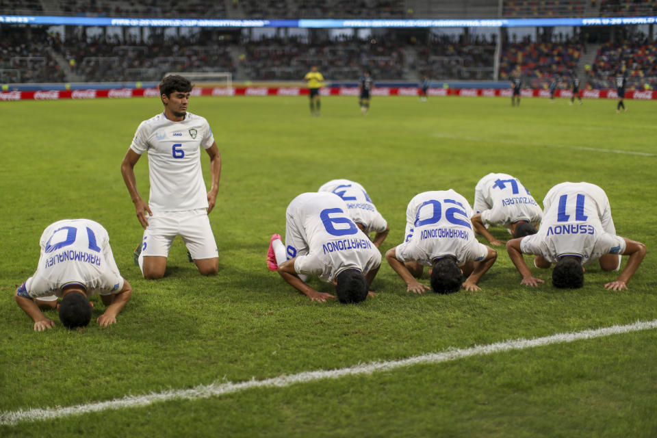 Uzbekistan's players genuflect after Shakhzodjon Nematjonov scored his side's opening goal against Guatemala during a FIFA U-20 World Cup Group A soccer match at the Madre De Ciudades stadium in Santiago del Estero, Argentina, Friday, May 26, 2023. (AP Photo/Nicolas Aguilera)